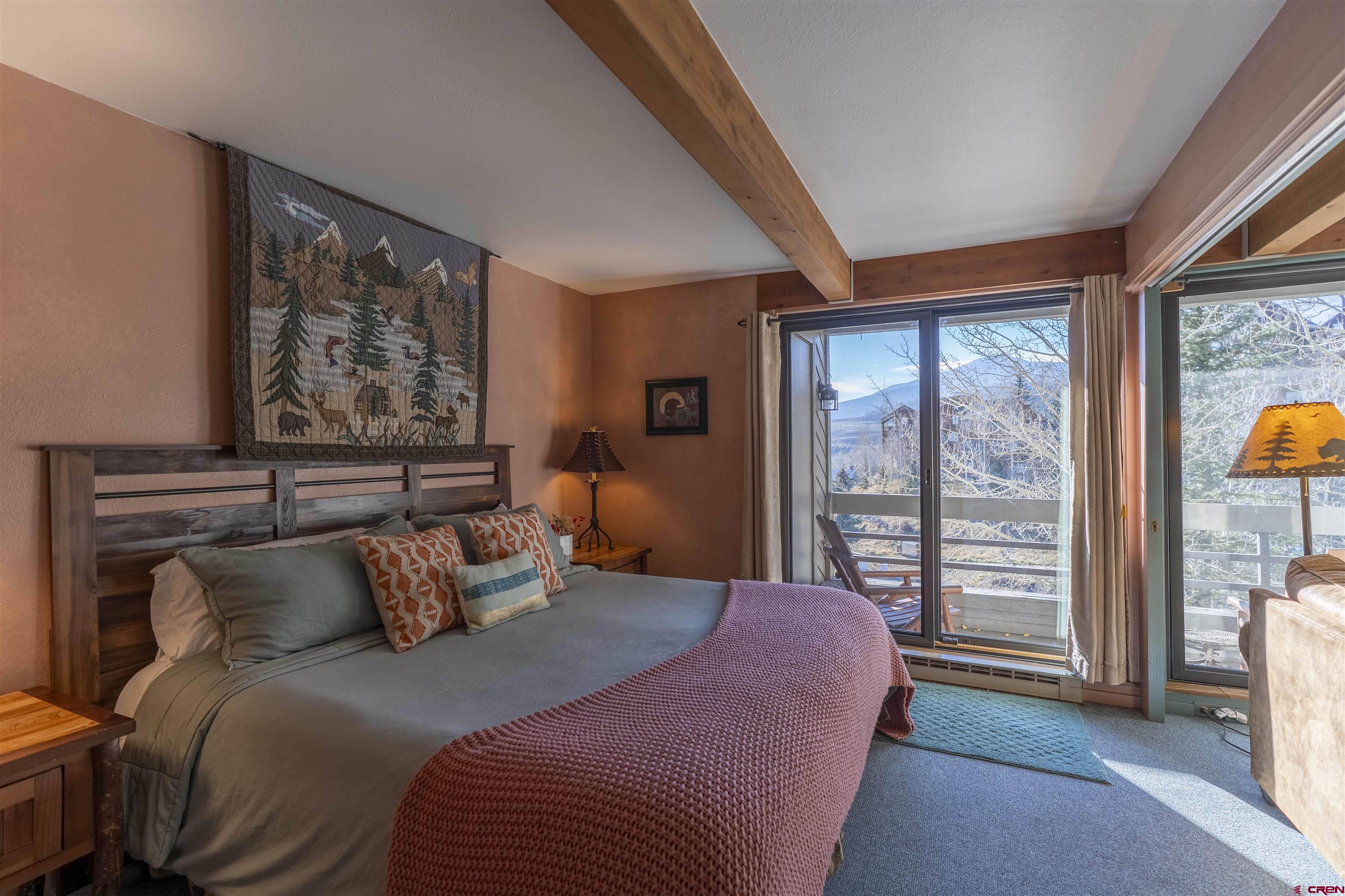 11 Hunter Hill Road, Unit 406 Crested Butte, CO 81225 - Photo 31 of 45 a bedroom with a large bed and a large window