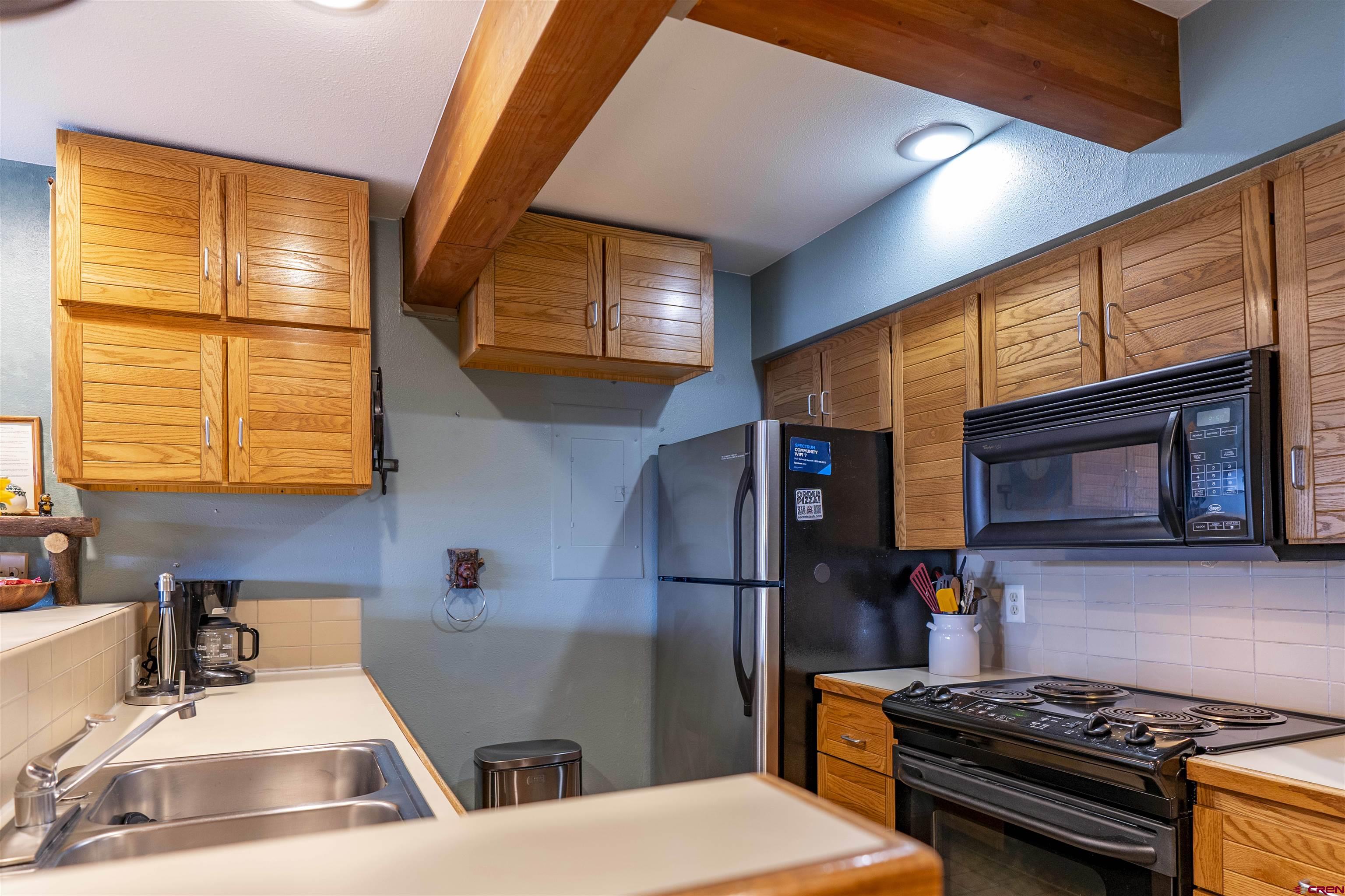 11 Hunter Hill Road, Unit 406 Crested Butte, CO 81225 - Photo 9 of 45 a kitchen with stainless steel appliances granite countertop a stove a sink and a microwave