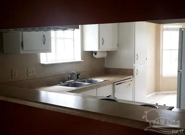 a kitchen with a sink a window and cabinets
