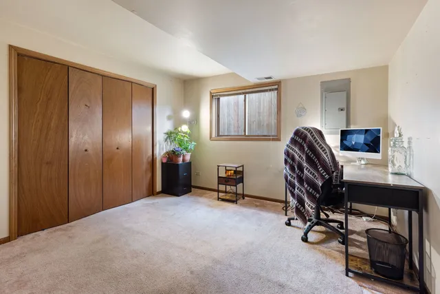 a view of a workspace with furniture and a window