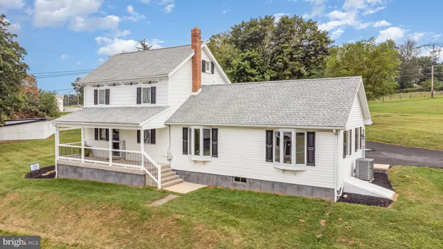 a front view of a house with a yard and trees