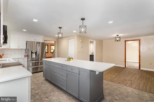 an empty room with wooden floor chandelier fan and windows