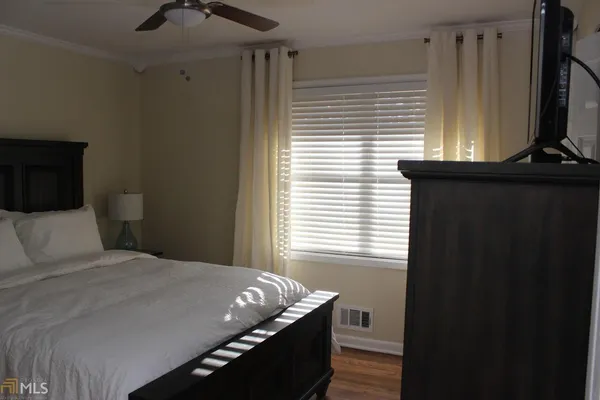 a bedroom with a bed and a flat tv screen