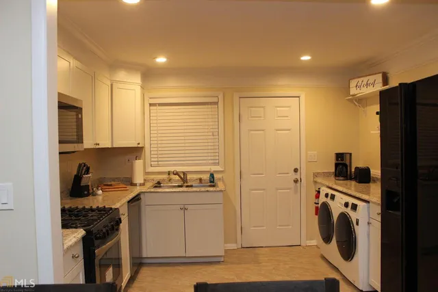 a kitchen with stainless steel appliances a stove a sink a refrigerator and cabinets
