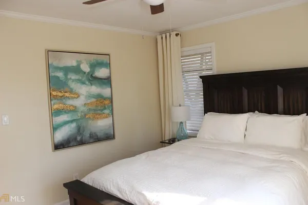 a bedroom with a bed and a painting on the wall