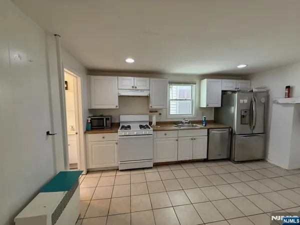 a kitchen with a refrigerator sink and cabinets