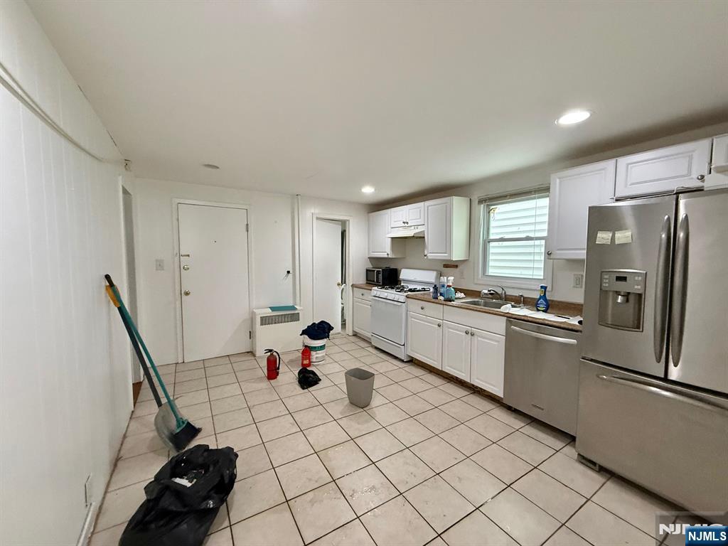 44 Washington Street, Unit 2F Harrison, NJ 07029 - Photo 5 of 9 a kitchen with white cabinets and white appliances