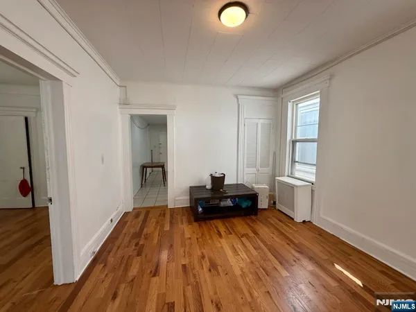 a view of a bedroom with wooden floor