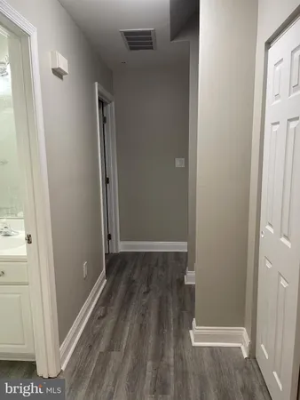 an empty room with wooden floor and entrance