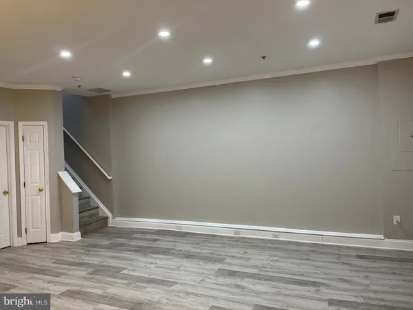 an empty room with wooden floor and stairs