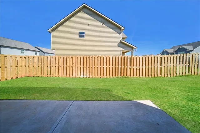 a view of a backyard with wooden fence