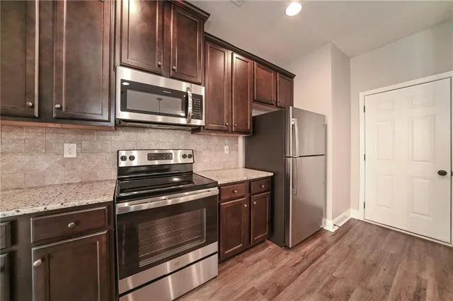 a kitchen with granite countertop wooden cabinets and stainless steel appliances