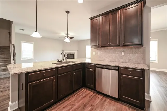 a kitchen with kitchen island granite countertop wooden cabinets and a sink
