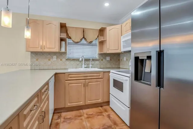a kitchen with stainless steel appliances granite countertop a refrigerator sink and cabinets