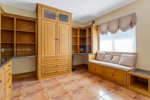 a living room with furniture cabinets and a window