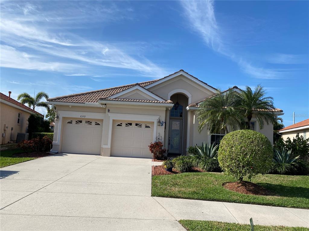 6372 Rookery Circle Bradenton, FL 34203 - Photo 2 of 46 a front view of a house with a yard and garage
