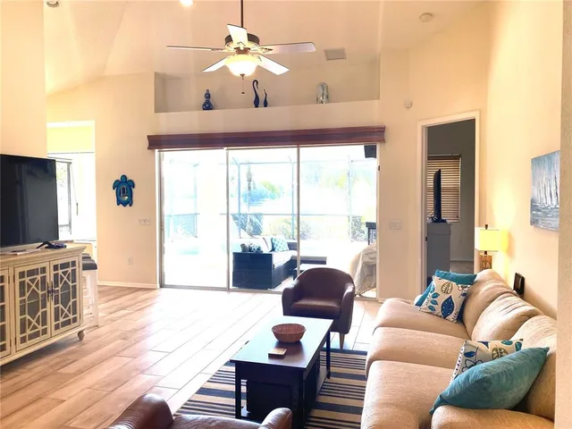 a living room with furniture a flat screen tv and a window