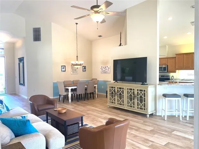 a living room with furniture a flat screen tv and kitchen view