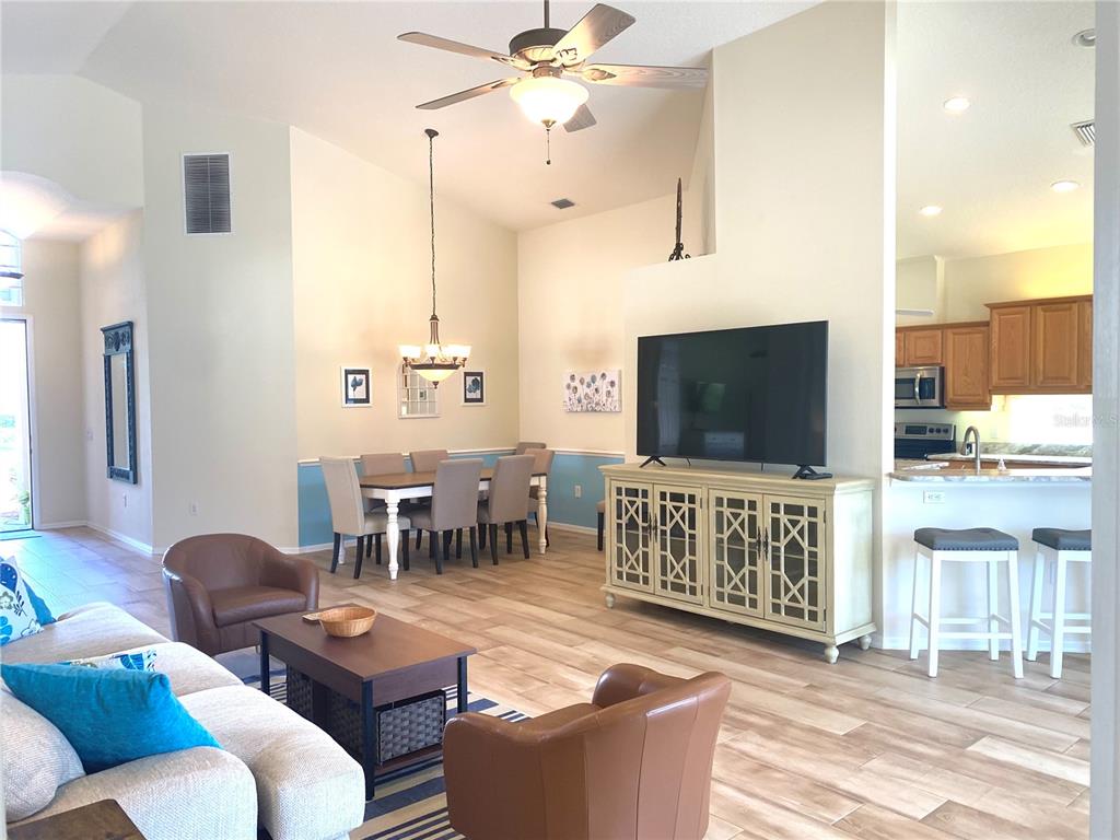 6372 Rookery Circle Bradenton, FL 34203 - Photo 9 of 46 a living room with furniture a flat screen tv and kitchen view
