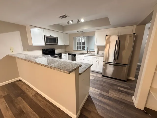 a kitchen with granite countertop a refrigerator stove and sink