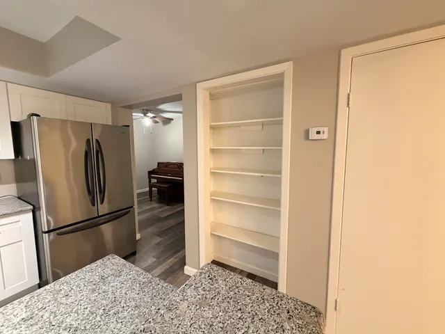 a walk in closet with wooden floor