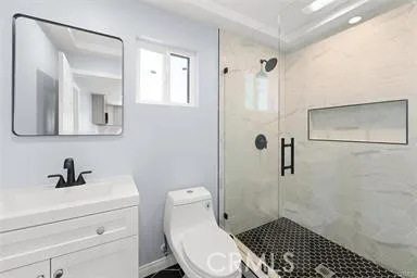 a bathroom with a toilet a sink a shower and mirror