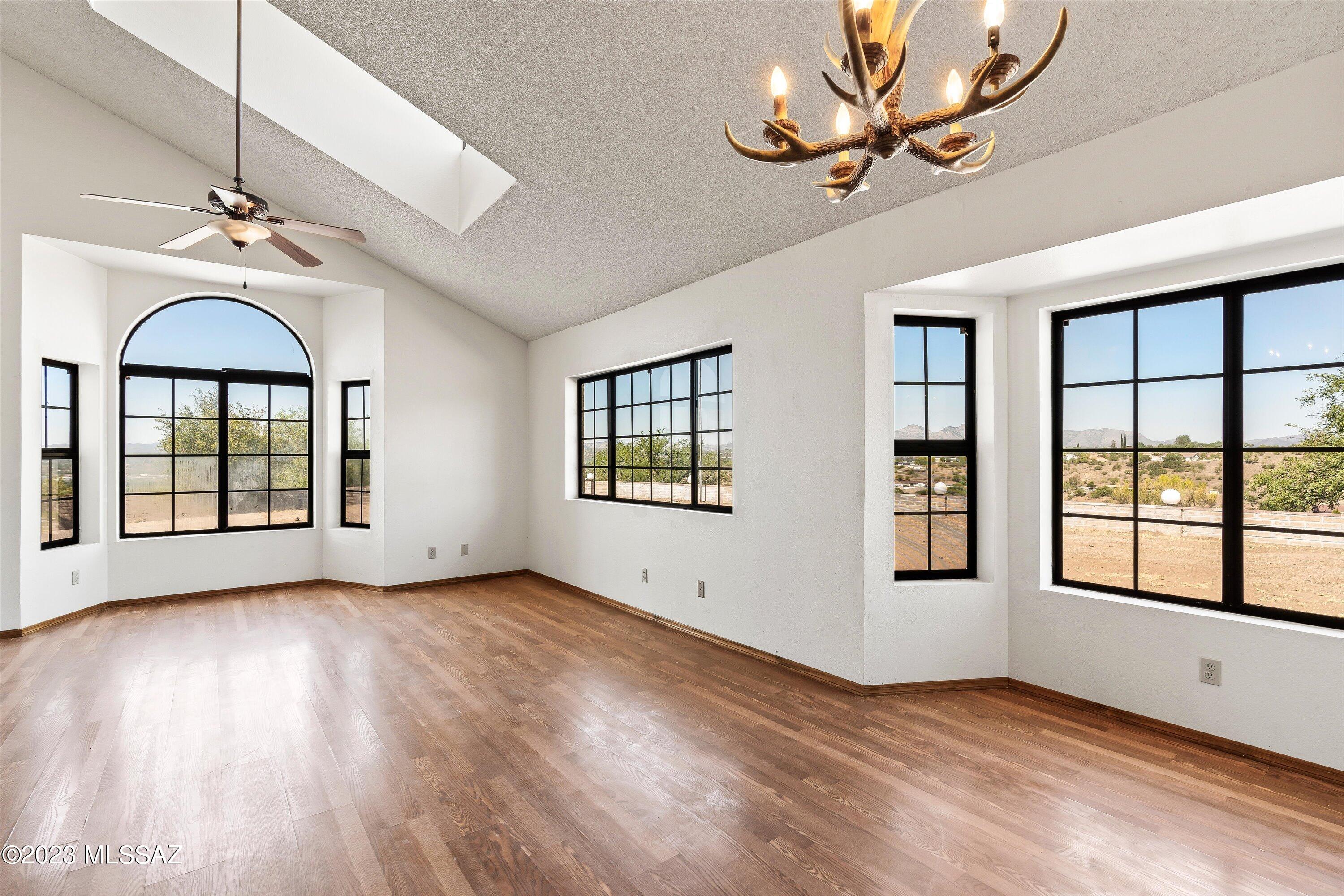 1226 Avenida Gloriosa Rio Rico, AZ 85648 - Photo 4 of 46 a view of an empty room with a window and wooden floor