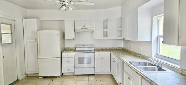 a kitchen with white cabinets and white appliances