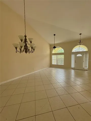 a view of a room with a chandelier fan and windows