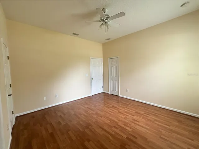 a view of empty room with wooden floor