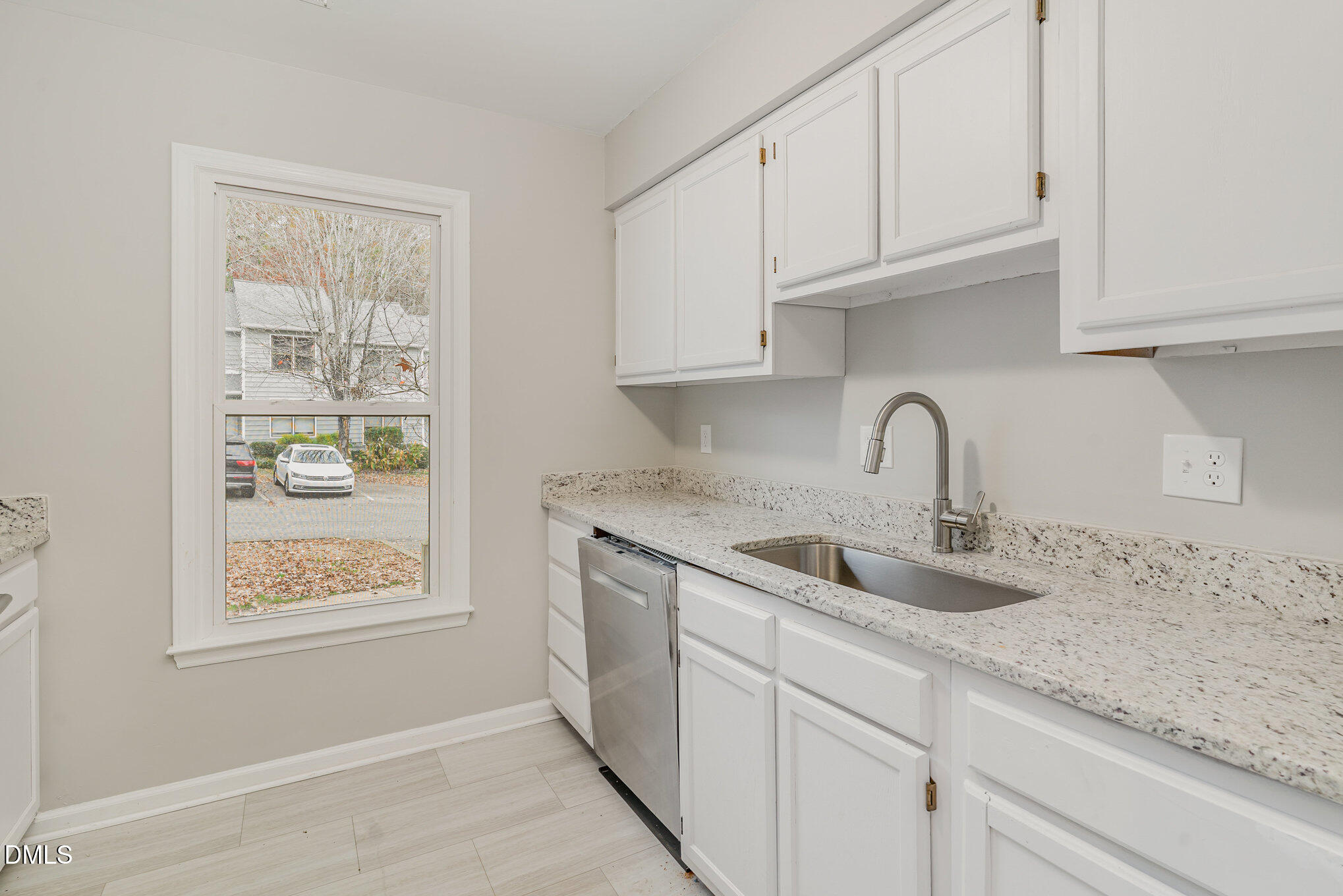 417 Applecross Drive Cary, NC 27511 - Photo 7 of 24 a kitchen with granite countertop white cabinets and window