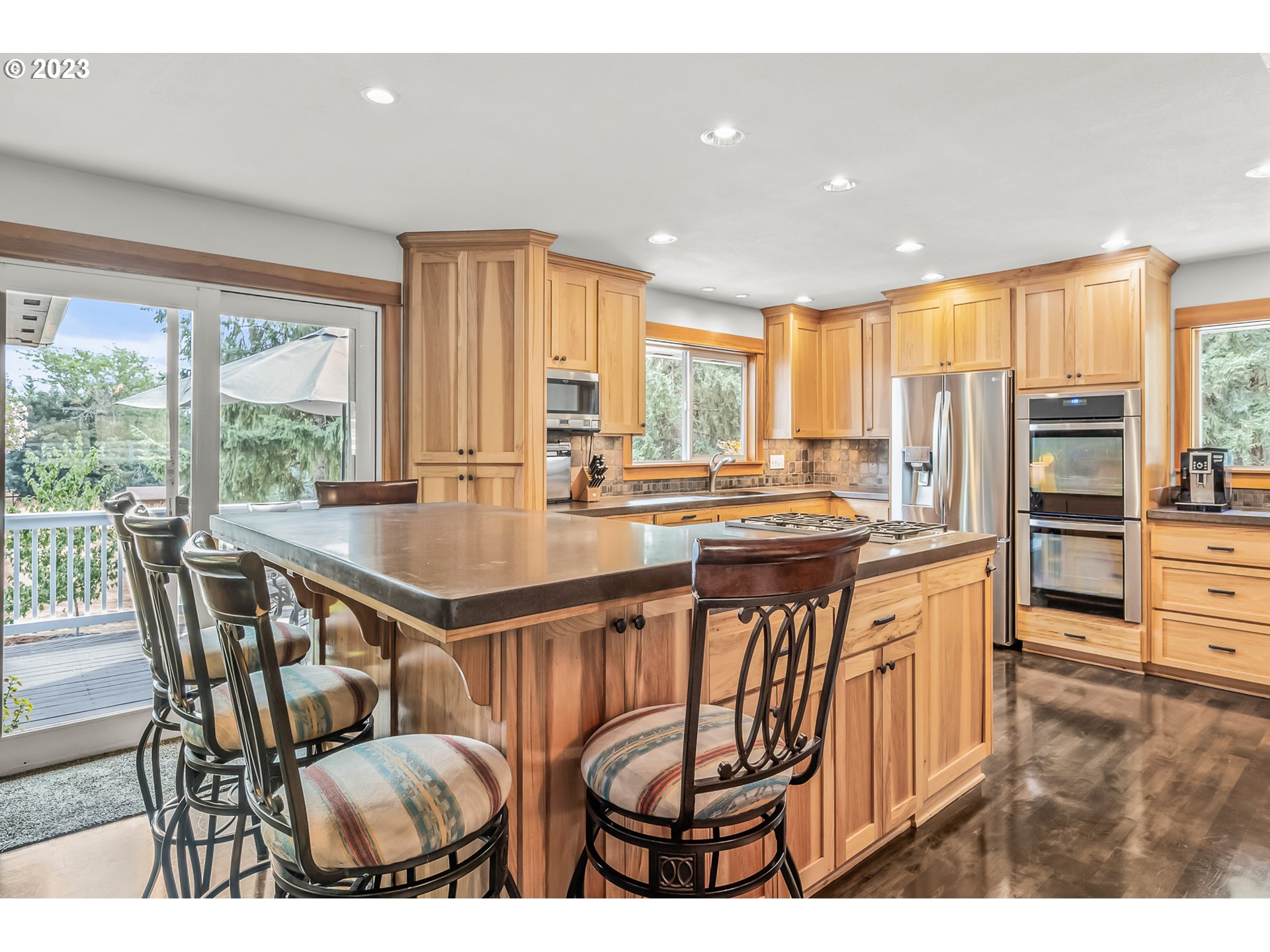 32311 Viewcrest Drive Warren, OR 97053 - Photo 11 of 46 a kitchen with stainless steel appliances granite countertop a stove a refrigerator a kitchen island a table and chairs