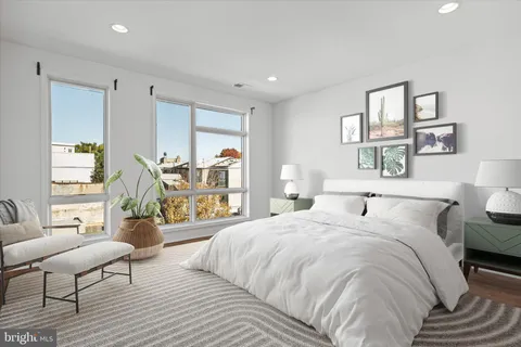 a bedroom with a large bed a couch and two windows