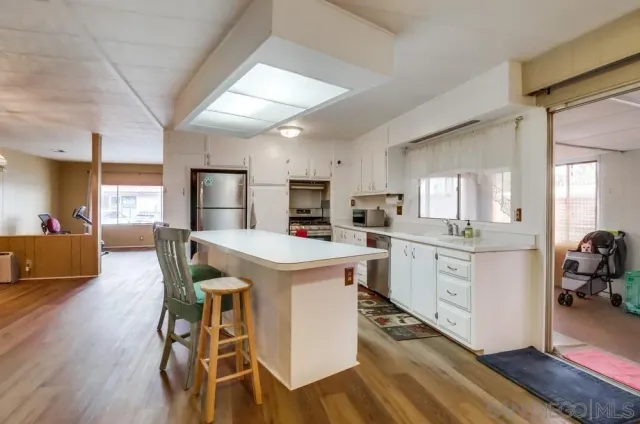 a kitchen with a table chairs refrigerator and cabinets