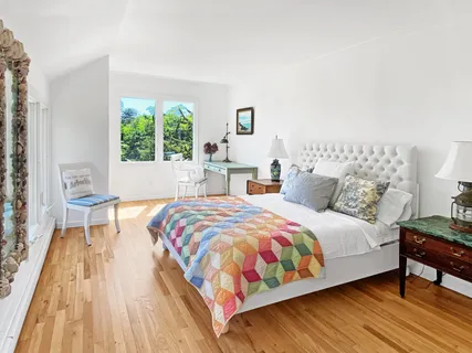 a bedroom with a bed and a large window