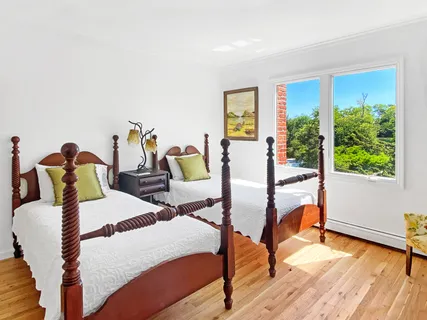 a bedroom with two beds and wooden floor