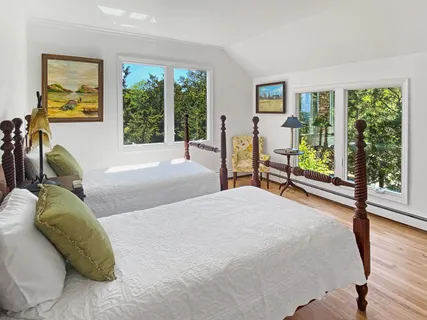 a bedroom with a bed and large windows