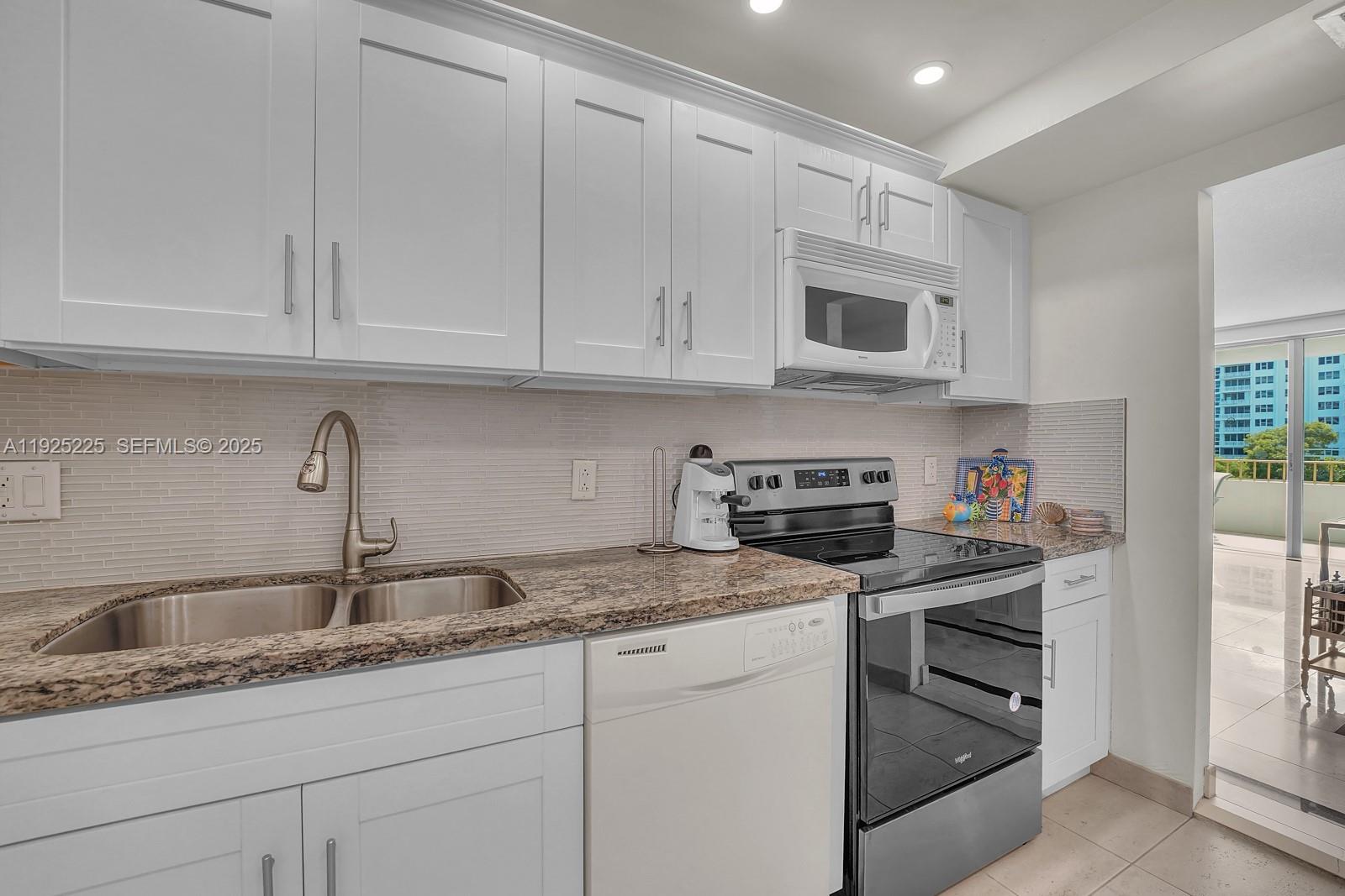 Key Biscayne Key Biscayne, FL 33149 - Photo 10 of 21 a kitchen with granite countertop white cabinets and white stainless steel appliances