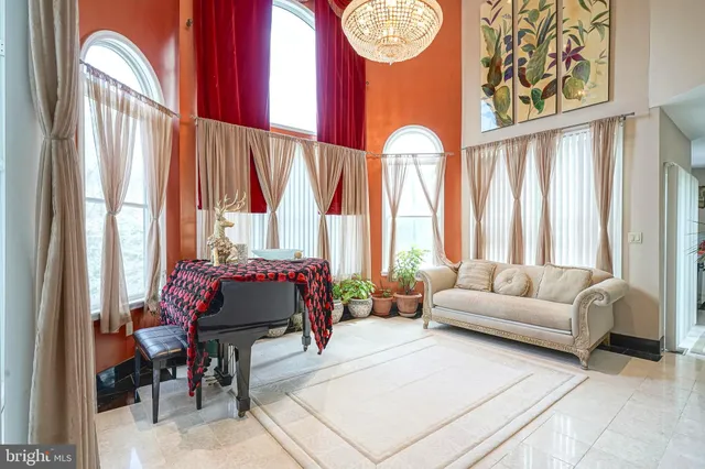 a living room with large windows and a chandelier
