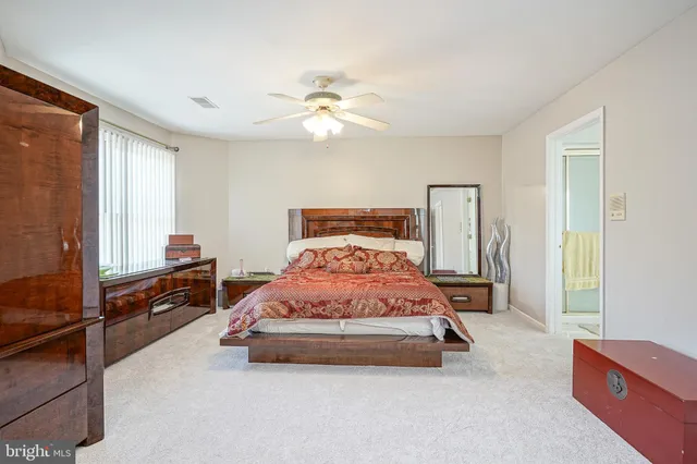 a bedroom with a bed and a flat tv screen on dresser
