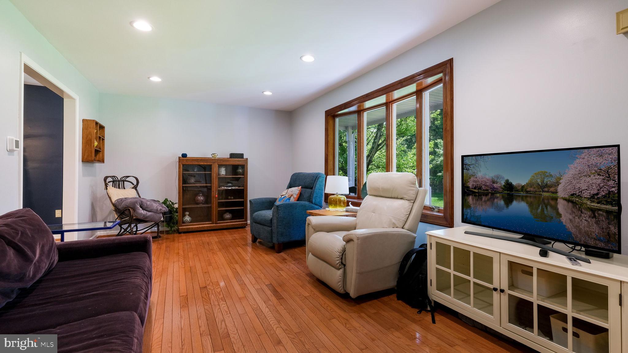 1270 Oxford Valley Road Yardley, PA 19067 - Photo 7 of 39 a living room with furniture a flat screen tv and a floor to ceiling window