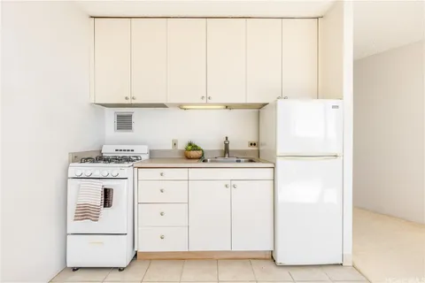 a kitchen with granite countertop white cabinets and white appliances
