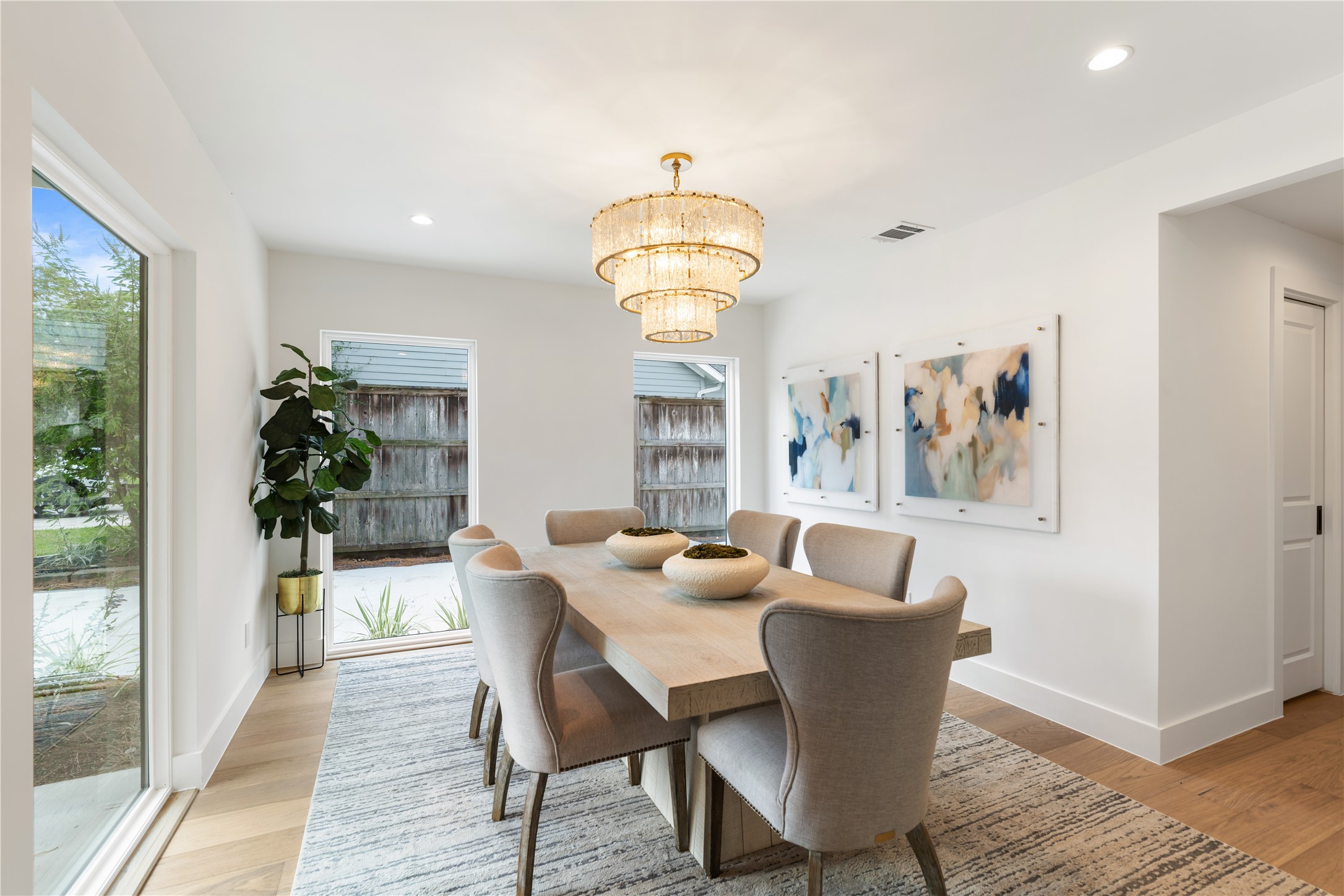 Elegant dining room with designer chandelier and abundant natural light