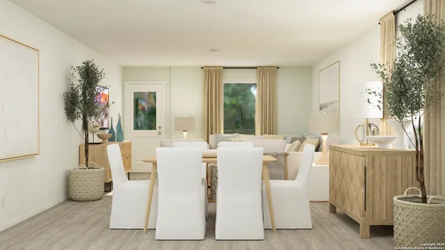 a living room with furniture a dining table and a potted plant