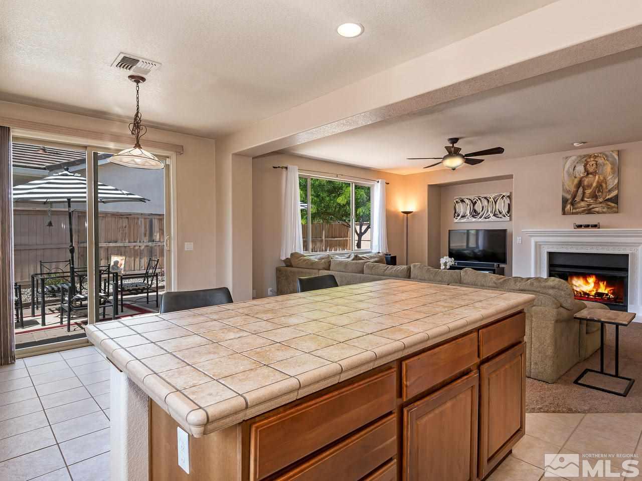 2598 Spring Flower Drive Reno, NV 89521 - Photo 11 of 21 a room with a bed and a fireplace with kitchen view