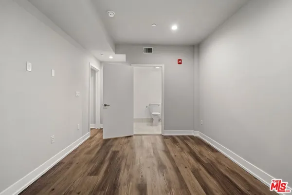 a view of a room with wooden floor and white walls