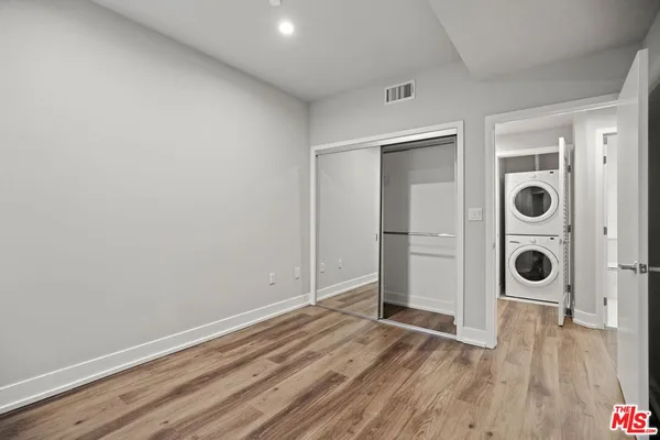 an empty room with wooden floor and closet