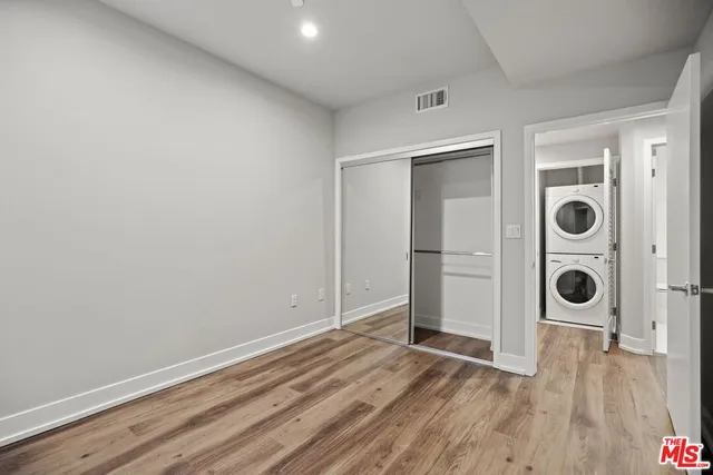 an empty room with wooden floor and closet