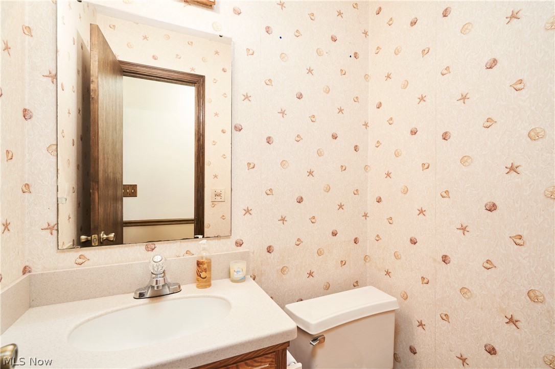3097 Baughman Road Clinton, OH 44216 - Photo 9 of 27 Bathroom vanity with an integrated sink, polished chrome faucet, and a large wall-mounted mirror