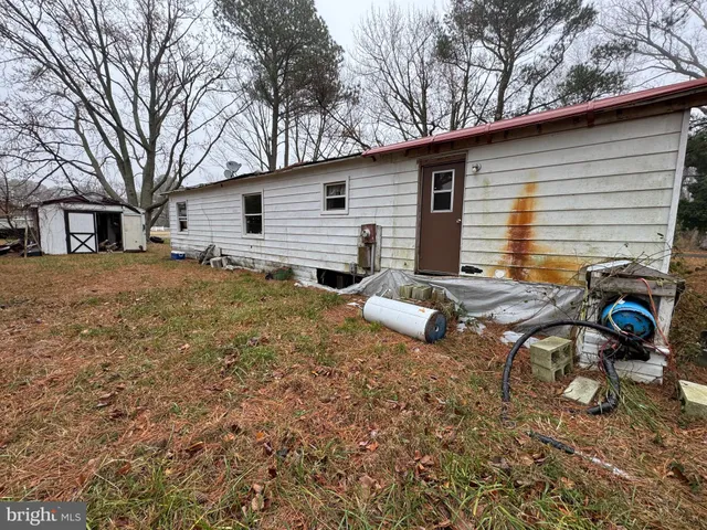 a backyard of a house with barbeque oven table and chairs